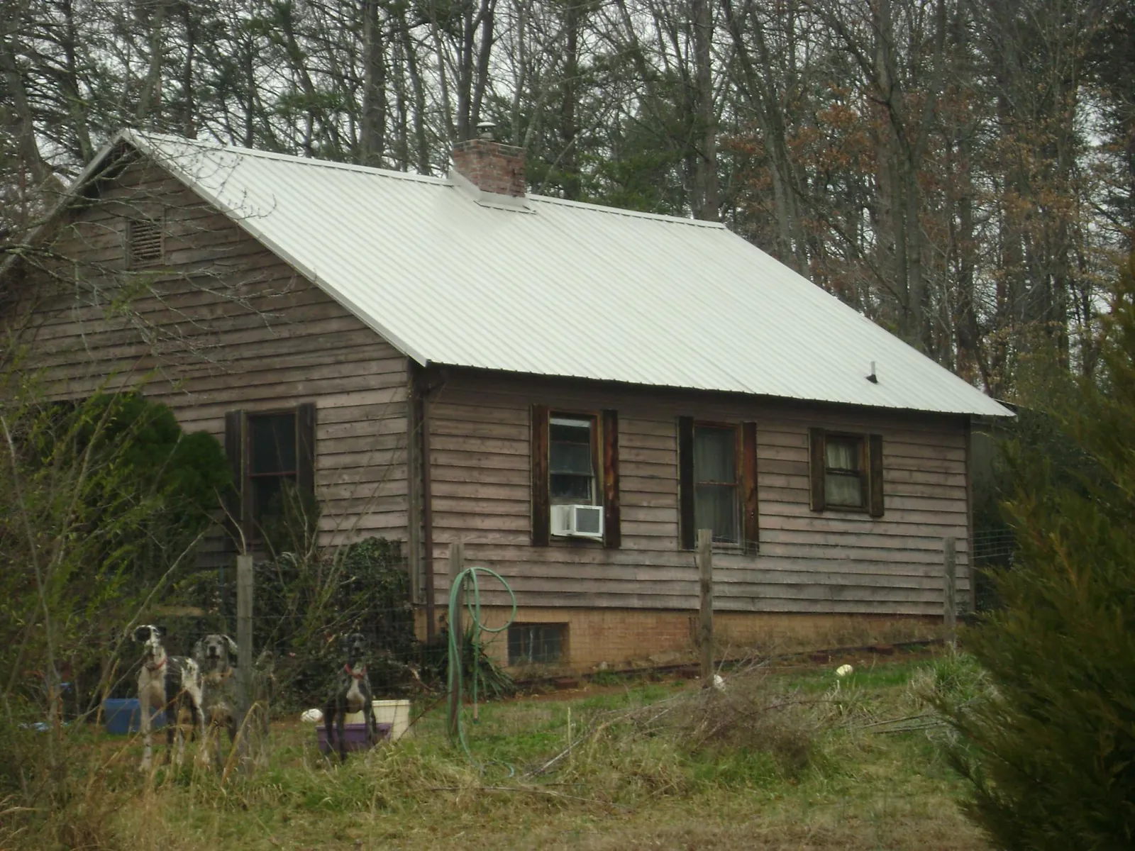 White metal roof on an old wood sided farmhouse, from a Metal Roof Installation job in Hubbard